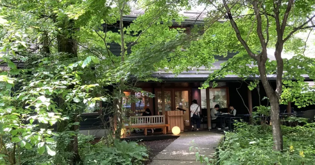 Wooden buildings among green trees with lanterns, in the Hoshino area of Karuizawa